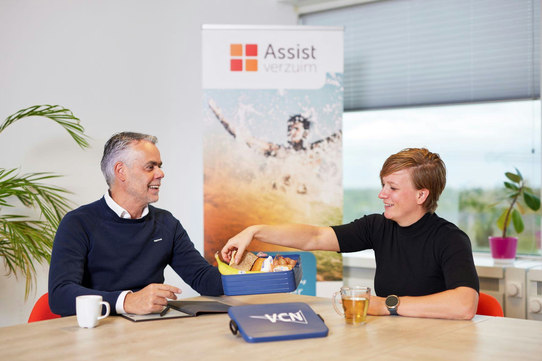 Aran van Wordragen (business partner Inkomen VCN) en casemanager Priscilla Vissers (arbodienst Assist Verzuim) spreken met elkaar over verzuimbegeleiding van werkgevers.
